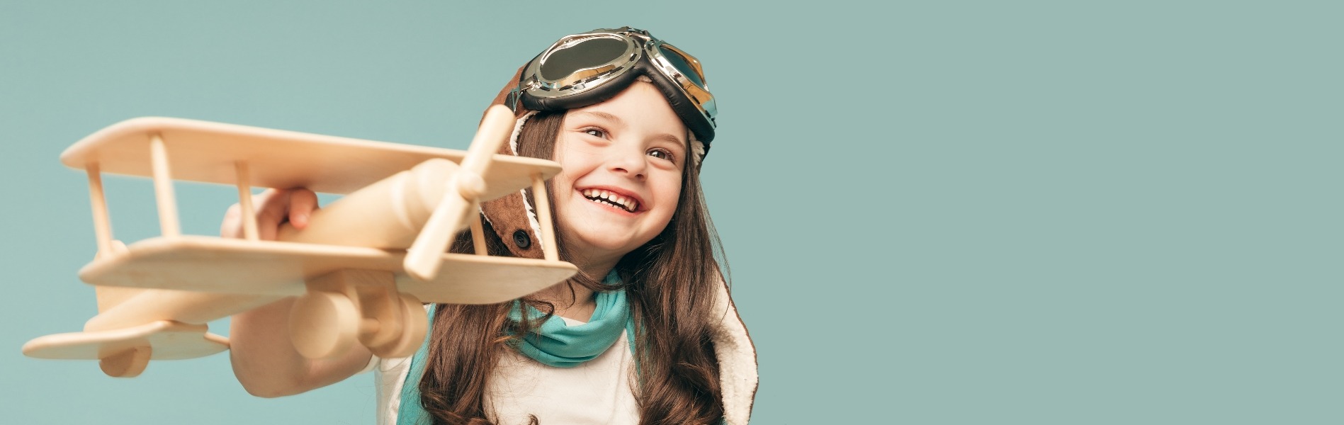 Little girl dressed as a pilot with model aeroplane